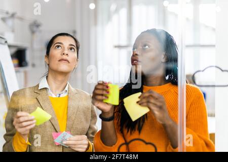 Responsabili di progetto e dipendenti che si occupano di brainstorming sulle idee - Gruppo multietnico dei lavoratori che hanno una riunione di affari in un ufficio di start-up Foto Stock