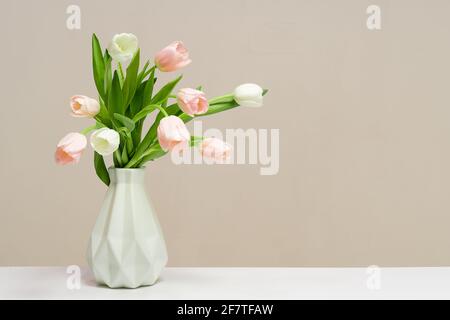 Bouquet di tulipani rosa in vaso bianco su sfondo azzurro. Sfondo delle festività, spazio di copia. San Valentino, Festa delle madri, concetto di compleanno Foto Stock