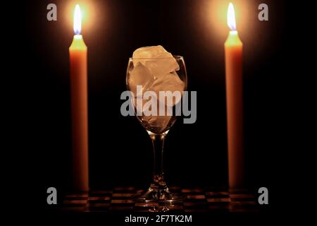 Due candele e un bicchiere d'acqua ghiacciata Foto Stock