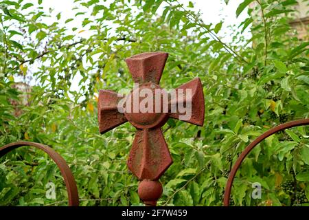 Weated bella croce di una chiesa ortodossa georgiana con verde Fogliame sullo sfondo Foto Stock