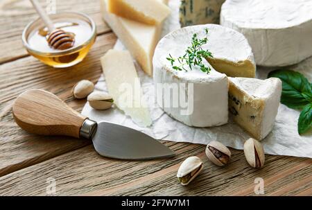 Vari tipi di formaggio, formaggio blu, bree, camambert su un tavolo di legno Foto Stock