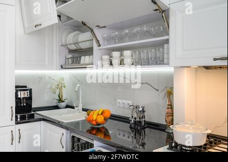 Lussuoso interno bianco moderno cucina, cassetti estraibili, porte aperte Foto Stock