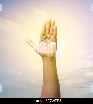 Mano di afroamericano uomo con testo AMICIZIA GIORNO all'aperto Foto Stock