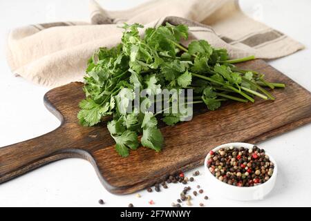 Tavola con coriandolo fresco e pepe misto su sfondo chiaro Foto Stock