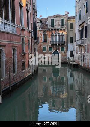 Piccola barca su una piccola strada canale a Venezia di belle case colorate, Italia Foto Stock
