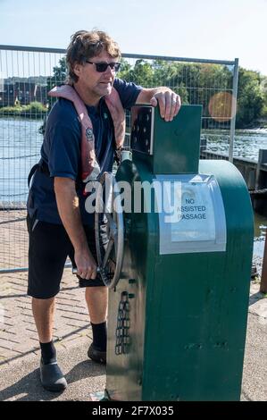 Il custode che aziona i cancelli al Temple Lock. Durante questi periodi pandemici, Temple Lock è circondato da alte barriere metalliche sul fiume ThameLoc Foto Stock