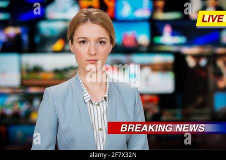 Una anchorwoman che riporta notizie dal vivo in studio TV. Sfondo di più schermi della sala di controllo delle trasmissioni. Concetto di giornalismo Foto Stock