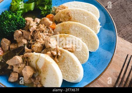 Stufato di vitello con gnocchi di lievito al vapore serviti con broccoli Foto Stock