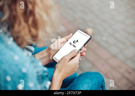 Podolsk, Ucraina - 29 marzo 2021: Donna che tiene smartphone con servizio sociale di Internet Tik Tok sullo schermo. Tiktok social network. Logo del Foto Stock