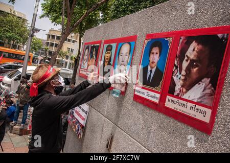 Un protestore appende i ritratti di persone morte nel '2010 aprile violenza' sul muro durante l'anniversario. L'ex leader principale e manifestanti del fronte Unito per la democrazia contro la dittatura (UDD), noto anche come 'camicia rossa', ha tenuto il 11esimo anniversario della 'violenza del 2010 aprile' al 14 ottobre 1973 Memorial a Bangkok. Più di 90 persone tra cui il cameraman televisivo giapponese Hiroyuki Muramoto e il fotografo italiano Fabio Polenghi sono morti nel '2010 aprile violence crackdown' da parte dell'esercito thailandese noto anche come 'sangue di aprile' o 'Cruel aprile' in Thailandia. (Foto di Peerapon Boonyakiat/SOPA Image Foto Stock