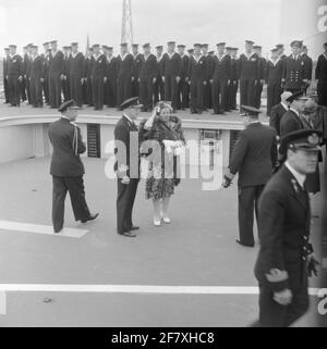 Momento fotografico dello stato Visita della coppia reale danese, Re Frederik IX e Regina Ingrid, nei Paesi Bassi. La compagnia reale e la sua Courtège decresce con l'aereo ascensore da HR. Sig.ra Karel Doorman (1948-1968). Fa parte della serie di oggetti AVDKM 540154 fino a 540167. Foto Stock