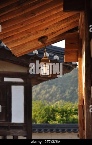 tradizionale lanterna coreana attaccata ad un tetto di hanok in un pomeriggio soleggiato nel villaggio folk di hahoe, andong, corea del sud Foto Stock