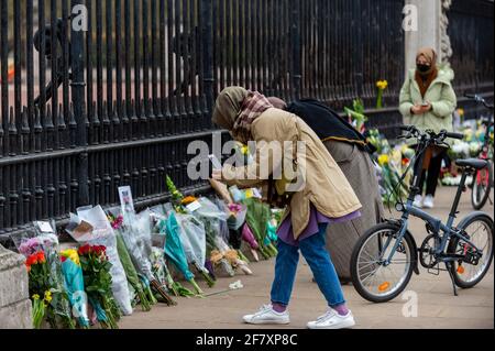 Londra, Regno Unito. 10 aprile 2021. Bene i wishers vedere i fiori fuori Buckingham Palace dopo la morte del principe Filippo, 99 anni, è stato annunciato il giorno precedente. Credit: Stephen Chung / Alamy Live News Foto Stock