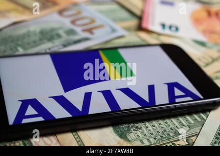 Viersen, Germania - 1 marzo. 2021: Closeup di smartphone con logo scritta della compagnia di assicurazione aviva su carta moneta Foto Stock