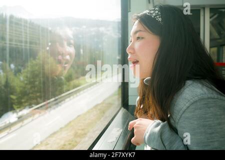 viaggio in treno fuga - stile di vita ritratto di giovani felici e. Bella donna cinese asiatica che viaggia sulla ferrovia guardando attraverso la finestra rilassato e che Foto Stock