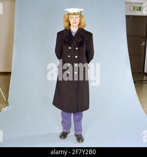 Marinaio femminile della marina reale (km) in tuta da lavoro blu con lungo cappotto invernale (1989). Foto Stock
