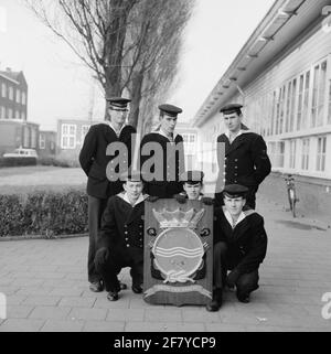 Foto di classe realizzata sul sito delle caserme marine di Amsterdam (MKAD) presso i corsi tecnici della Royal Netherlands Marine (Toka). Una classe con pochi costruttori di aeromobili (VGMR) si pone con lo stemma del Tockm. Foto Stock