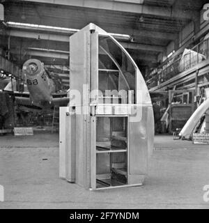 La sala di assemblaggio e produzione della fabbrica di aerei Aviolaland intorno al 1950, dove furono costruiti e mantenuti vari aeromobili e parti di aeromobili per il Marine Amaestry Service (MLD) e la Royal Netherlands Air Force (KLU). Sullo sfondo l'aereo da yacht Fairey Firefly Mk.iv K-68 (1947-1959) del servizio di trasporto aereo marino (MLD). Foto Stock