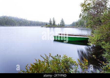 vista su una canoa su un lago foggoso nelle prime ore del mattino la mattina prima dell'alba Foto Stock