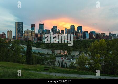 Vista del centro città con edifici alti al tramonto estate con fiume sul davanti Foto Stock