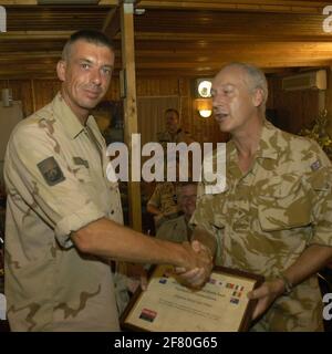 Il Comandante Multi-National Division (Sud Est) presenta al Sergente olandese maggiore Otten una prospettiva di soddisfazione. Foto Stock