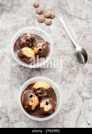 Profiteroles freschi con salsa al cioccolato. Foto Stock