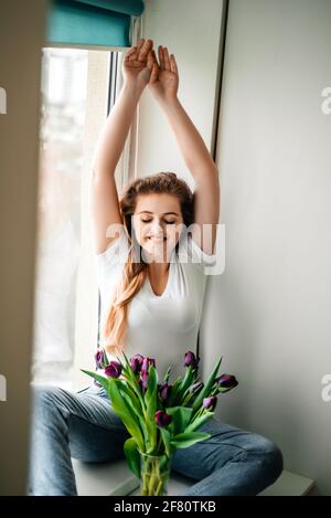 Amabile ragazza femminile nel fine settimana mattina. Bouquet di tulipani Foto Stock