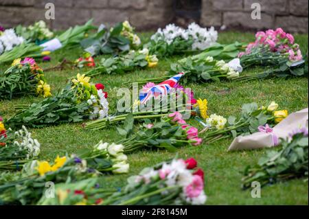 Windsor, Berkshire, Regno Unito. 10 aprile 2021. Centinaia di persone erano a Windsor oggi portando tributi floreali per sua Maestà la Regina dopo la triste passata ieri del suo amato marito, S.A.R. il Principe Filippo, il Duca di Edimburgo. I fiori venivano collocati sull'erba fuori dalle porte del Castello di Windsor sulla Long Walk. Molte stazioni TV erano in Windsor che trasmette in diretta oggi. È stato annunciato che i funerali di S.A.R. il Principe Filippo saranno un evento privato che si terrà nella Cappella di San Giorgio sabato 17 aprile 2021. Credito: Maureen McLean/Alamy Foto Stock