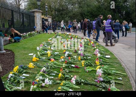 Windsor, Berkshire, Regno Unito. 10 aprile 2021. Centinaia di persone erano a Windsor oggi portando tributi floreali per sua Maestà la Regina dopo la triste passata ieri del suo amato marito, S.A.R. il Principe Filippo, il Duca di Edimburgo. I fiori venivano collocati sull'erba fuori dalle porte del Castello di Windsor sulla Long Walk. Molte stazioni TV erano in Windsor che trasmette in diretta oggi. È stato annunciato che i funerali di S.A.R. il Principe Filippo saranno un evento privato che si terrà nella Cappella di San Giorgio sabato 17 aprile 2021. Credito: Maureen McLean/Alamy Foto Stock