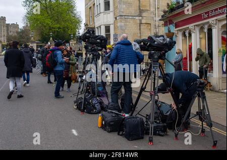 Windsor, Berkshire, Regno Unito. 10 aprile 2021. Centinaia di persone erano a Windsor oggi portando tributi floreali per sua Maestà la Regina dopo la triste passata ieri del suo amato marito, S.A.R. il Principe Filippo, il Duca di Edimburgo. I fiori venivano collocati sull'erba fuori dalle porte del Castello di Windsor sulla Long Walk. Molte stazioni TV erano in Windsor che trasmette in diretta oggi. È stato annunciato che i funerali di S.A.R. il Principe Filippo saranno un evento privato che si terrà nella Cappella di San Giorgio sabato 17 aprile 2021. Credito: Maureen McLean/Alamy Foto Stock