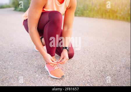 Sportive la legatura i suoi lacci delle scarpe prima del training. Foto Stock