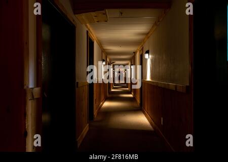 lungo corridoio in una cabina di legno con luce proveniente da le pareti Foto Stock