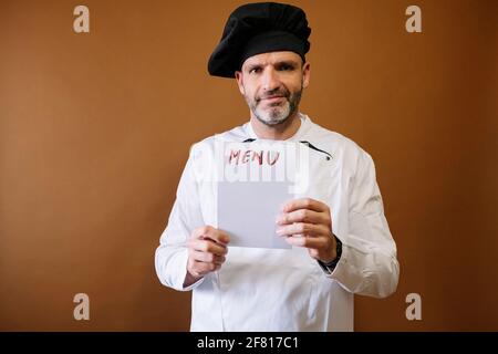 Chef uomo con un cartello che dice menu Foto Stock