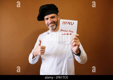 Chef uomo con un cartello che dice menu Foto Stock