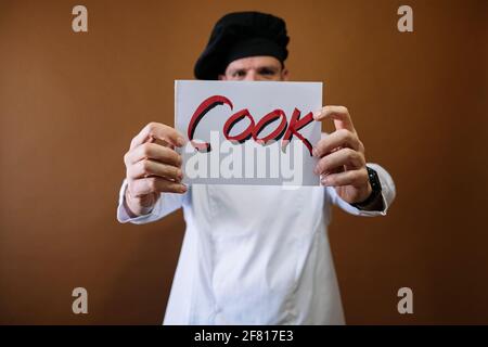 Chef uomo con un segno che dice cuoco Foto Stock