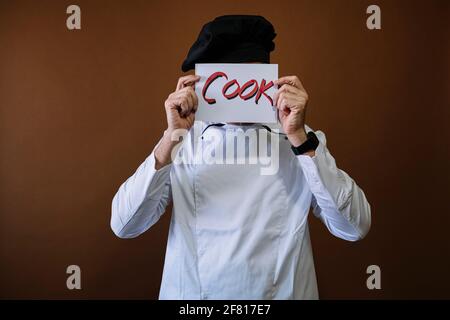 Chef uomo con un segno che dice cuoco Foto Stock