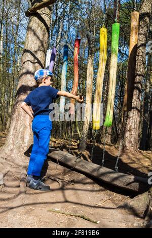 Una stazione della Boszorkany meseosveny (Strega sentiero didattico nel bosco), un kid bambino colpendo verticale bastoncini di legno rendendo il suono, Sopron, Ungheria Foto Stock