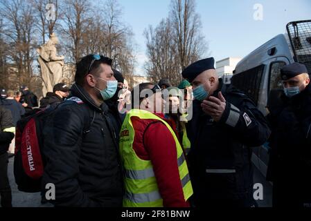 10 aprile 2021, Varsavia, Varsavia, Polonia: Un dimostrante si oppone ad un ufficiale di polizia durante una protesta contro il governo il 10 aprile, a Varsavia, Polonia. Alcune dozzine di persone si sono riunite in piazza Pilsudskiego a Varsavia per protestare contro il governo e le ultime restrizioni introdotte per frenare la diffusione di Sars-COV-2. La manifestazione è stata organizzata lo stesso giorno dell'undicesimo anniversario dell'incidente aereo di Smolensk al quale partecipa, nonostante le restrizioni, il leader del partito al potere, Jaroslaw Kaczynski, accompagnato da una dozzina di altri rappresentanti del governo. (C Foto Stock