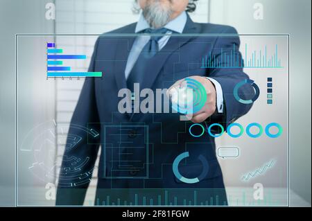 Un uomo d'affari lavora su un'interfaccia touchscreen con tecnologia nei dati aziendali. Stile futuristico, su sfondo blu. Foto Stock