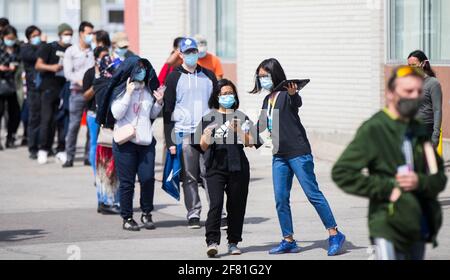 Toronto, Canada. 10 Apr 2021. Le persone che indossano maschere facciali si allineano per entrare in una clinica vaccinale COVID-19 a Toronto, Canada, il 10 aprile 2021. A partire da sabato pomeriggio, il Canada ha segnalato 5,986 nuovi casi di COVID-19, portando il totale cumulativo a 1,051,246, di cui 23,282 morti, secondo CTV. Credit: Zou Zheng/Xinhua/Alamy Live News Foto Stock