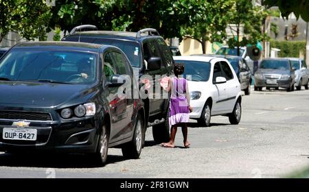 salvador, bahia / brasile - 24 dicembre 2014: Il bambino è visto chiedendo donazioni nel mezzo del traffico di veicoli nel quartiere Pituba di Salvado Foto Stock