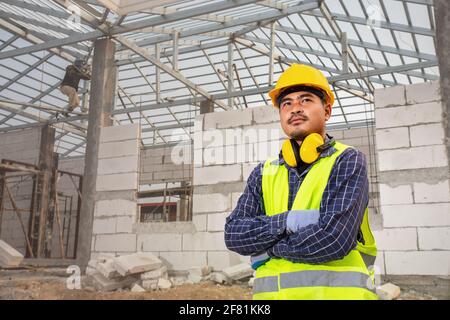 Ritratto di tecnico di costruzione lavoratore, ingegnere civile controllo lavori struttura del tetto di casa incompiuta presso il cantiere, Casa c Foto Stock