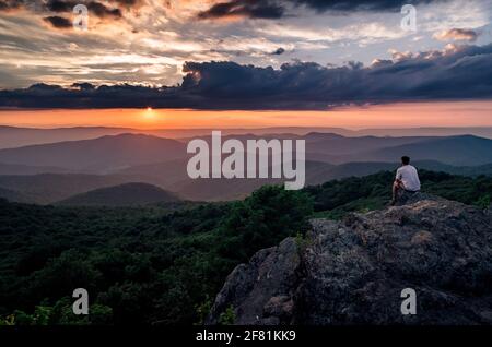 Un escursionista che prende in un tramonto estivo dalla montagna Bearfence nel Parco Nazionale di Shenandoah. Foto Stock