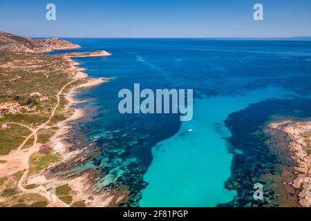 Vista aerea di una barca gonfiabile rigida ormeggiata in un Canale turchese traslucido nel Mediterraneo a la Revellata in La regione Balagne della Corsica Foto Stock