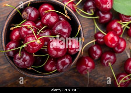 Ciliegie raccolte di fresco in una ciotola di argilla dal vostro giardino domestico. Concetto di cibo sano Foto Stock