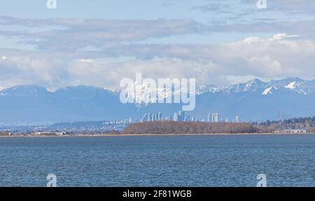 Splendida vista panoramica sul mare e sulla città di Richmond, nella British Columbia, e splendide montagne sullo sfondo. Vista sulla strada, foto di viaggio, Foto Stock