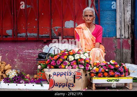 donna che vende fiori freschi sulla strada, Port Louis, Mauritius Foto Stock
