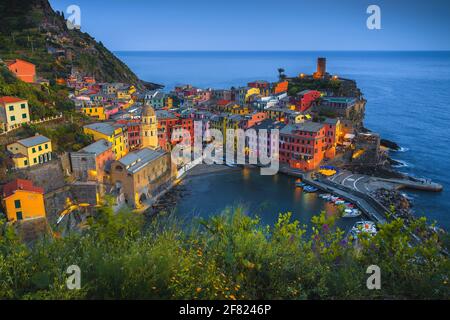 Bellissima vista sul borgo di Vernazza dal giardino fiorito con case colorate e piccolo porto al tramonto, cinque Terre, Liguria, Italia, Europa Foto Stock