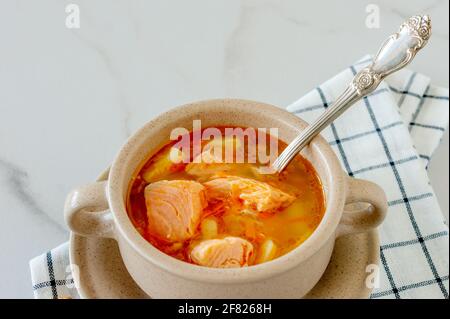 zuppa fatta in casa con salmone con bastoncini di pane su sfondo marmoreo Foto Stock