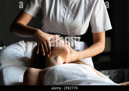 Donna giovane e sana nel salone termale. Massaggi tradizionali e trattamenti di bellezza. Foto Stock